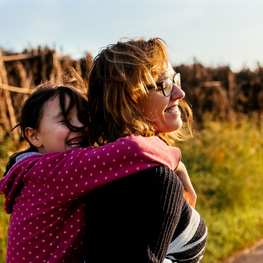 Mother and daughter enjoying a walk in the countryside at sunset